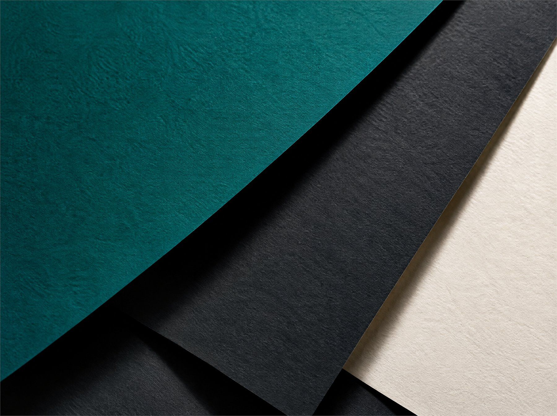 Gelaagde vellen papier in turquoise, antraciet en gebroken wit, scherp afgesneden